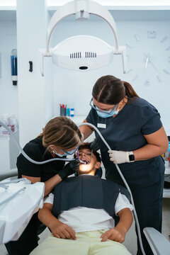 Dentists performing dental examination on young male patient
