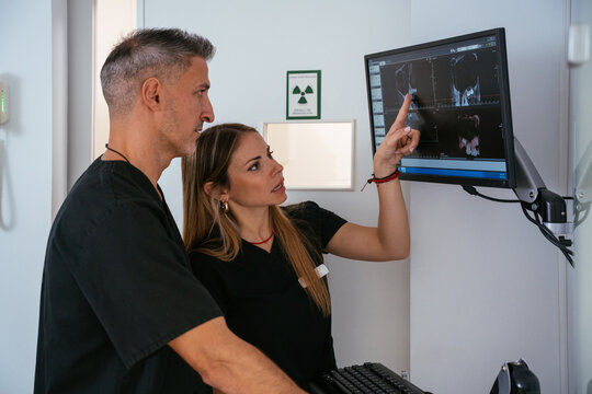 Dental professionals analyzing x-rays on monitor for diagnosis