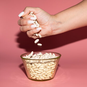 Jud&iacute;a o alubia blanca cruda a granel en el pu&ntilde;o de una mujer