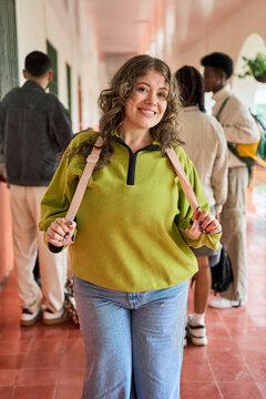 Portrait of a young woman student smiling on university hallway
