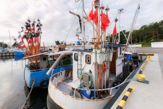 Pomeranian catch industry as fishing boats moored along quay in Ustka harbor Poland for regional maritime industry illustration and Baltic port documentation use.
