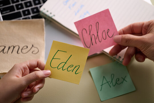 Hands holding sticky notes with names
