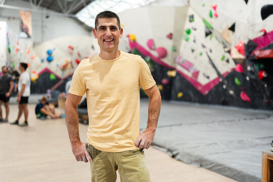 Happy man bouldering gym smiling after climbing session