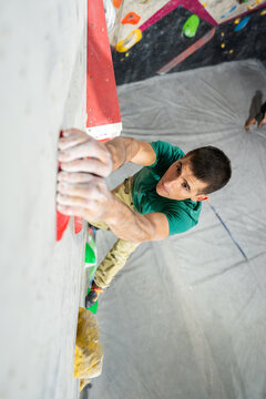 Man bouldering climbing indoors training for strength