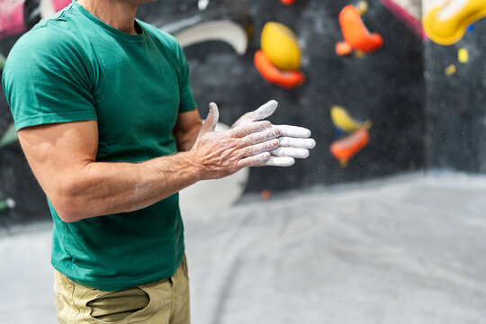 Man chalking hands for bouldering climbing preparation