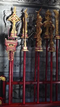 Vertical shot: Traditional weapons standing by the temple door.