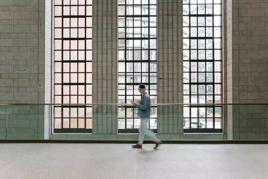 Man Walking Past Large Windows