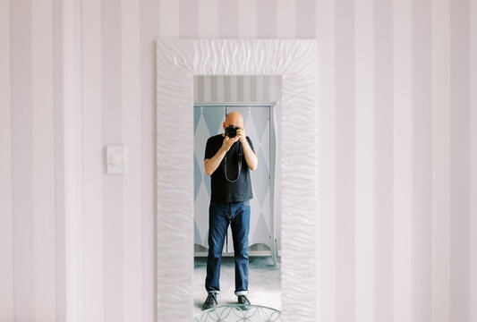Person Taking a Photo in a Stylish Room With a Mirror