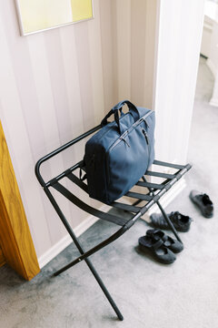 Bag Resting on a Luggage Rack Near Door in a Cozy Room