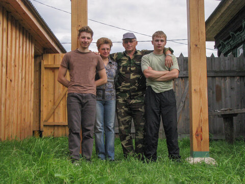 Family standing together in wooden backyard