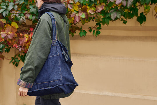 Walking through a colorful urban scene with a stylish denim bag 