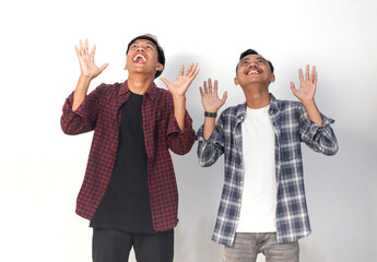 Obraz premium Asian man wearing a shirt with an excited expression is looking up on an isolated white background.