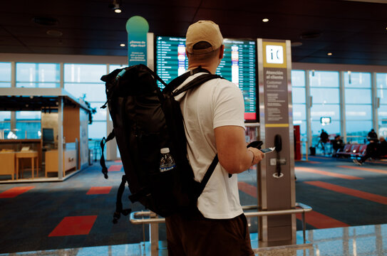 Traveler Checking Flight Information at the Airport in the Evening