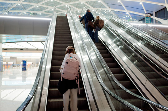 Travelers Ascending Escalator at Modern Airport
