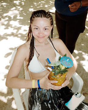 Enjoying a Refreshing Drink on the Beach During the braids process