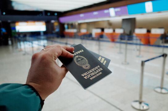 Holding Passports at the Airport Check-In Area on a Travel Day