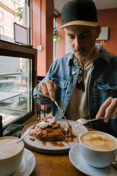 Man cutting pancakes at caf&eacute;