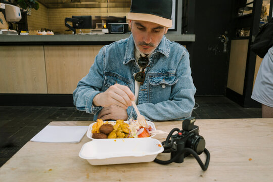 Man eating lunch at market stall