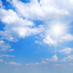 Bright Sun Shining in a Clear Blue Sky with Fluffy White Clouds