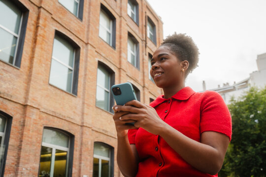 Smiling woman send texts in the city