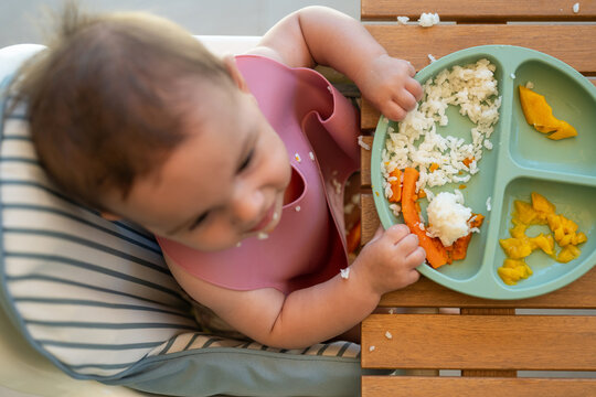 Top View Of Baby Eating On High Chair 