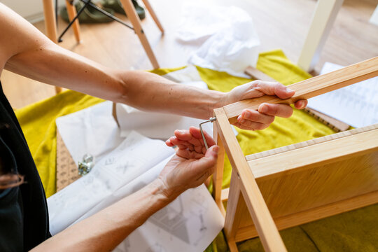 Close-Up of Hands Assembling Wooden Furniture