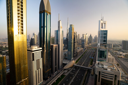 Aerial view of the gleaming skyscrapers and bustling highways stretch out towards the horizon, a symphony of gold and steel, Dubai, Dubai, United Arab Emirates.