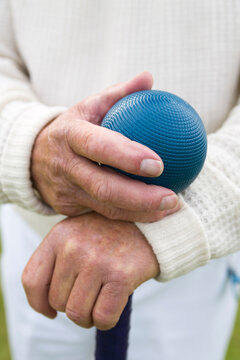 Senior hand hold croquet ball 