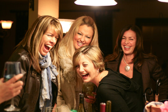 Four women laughing at a party