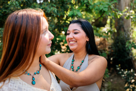 Woman Helping Friend Try On Handmade Turquoise Necklace