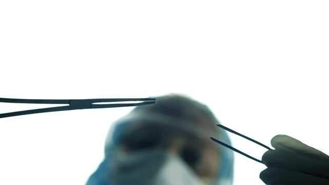 Surgeon Holding Medical Forceps And Tweezers During Surgery In Operating Room
