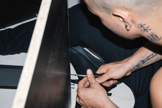 Man Assembling Furniture With a Screwdriver in a Home Setting