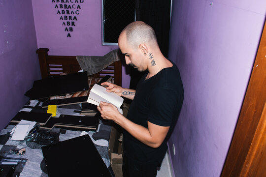 Person Assembling Furniture in a Bedroom With Black Panels