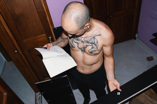 Man Studies Assembly Instructions While Building Furniture