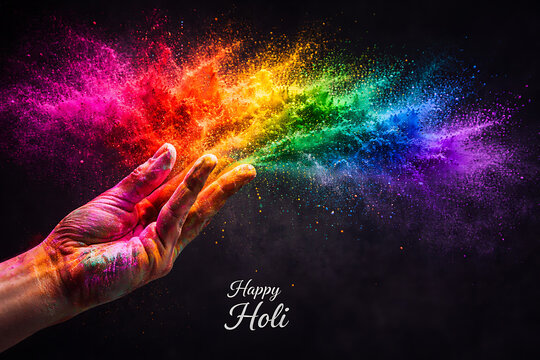 Hand throwing bright colorful powder in the dark air celebrating the beautiful spring holi and holika dhan festival representing joyous rang panchami festive party background