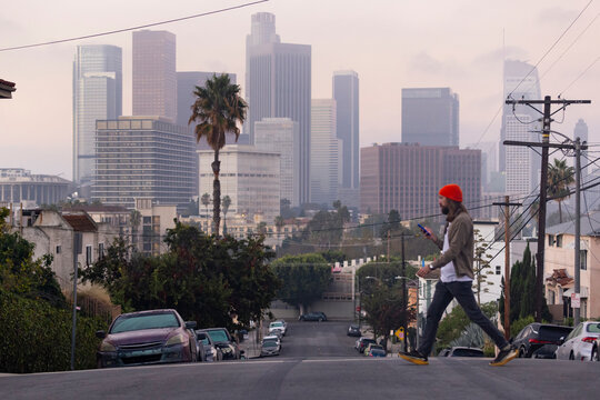 Man walking street Los Angeles skyline background