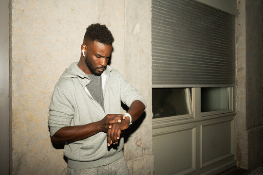 Man Checking Watch in Urban Setting at Night