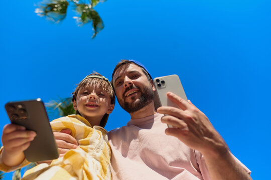 Father and Son Taking a Selfie Under Blue Sky