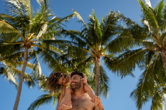 Father and daughter under palm trees hamilton island