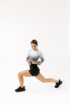 Fit Woman Performing Lunge Exercise With Weights on white background