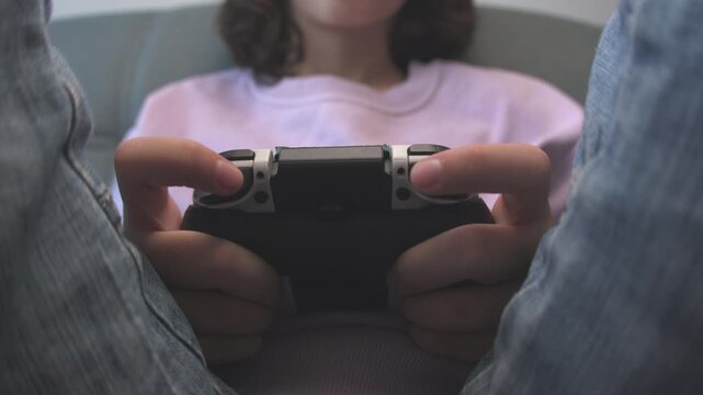 Boy playing a video game. Close-up. Gamer playing a video game on a console with a joystick. Video games.