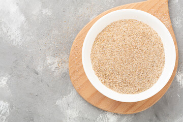 Psyllium husk powder with fresh leaves on concrete background, top view