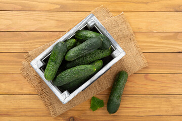 Cucumbers with leaves on wooden background,top view