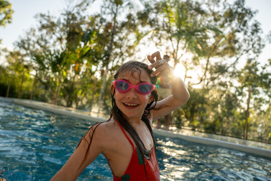 Happy child swimming in outdoor pool on a sunny day
