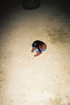 Woman lighting up a firecracker in a field