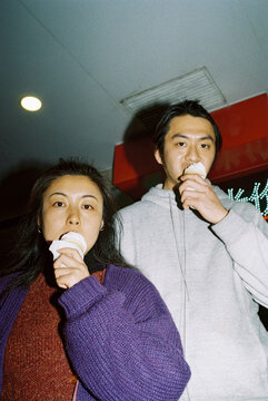 Couple eating ice cream facing the camera