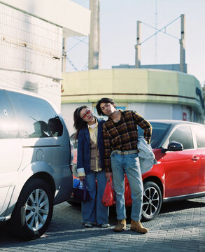 Portrait of a Chinese couple in front of cars 