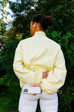 Active lifestyle moment Woman holding smartphone behind her back