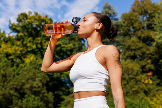 Woman drinking water from bottle after outdoor workout