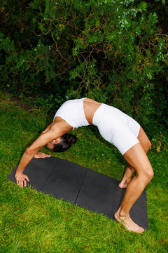 Flexible Woman in White Activewear Doing Bridge Pose